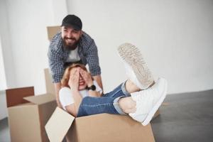 couvrant les yeux. couple heureux ensemble dans leur nouvelle maison. conception du déménagement photo