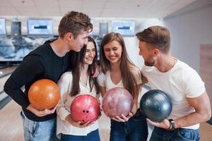 bonne blague. de jeunes amis joyeux s'amusent au club de bowling le week-end photo