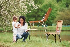 vous devez être patient pour cela. apprendre à peindre à sa petite-fille. dans le parc naturel photo