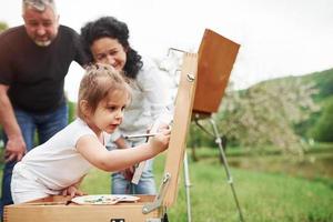 ça aura l'air génial. grand-mère et grand-père s'amusent dehors avec sa petite-fille. conception de la peinture photo