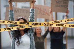 bande couvrant les yeux de la fille. un groupe de femmes féministes manifestent pour leurs droits à l'extérieur photo