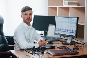 chemise blanche et beaucoup d'appareils. l'examinateur polygraphique travaille au bureau avec l'équipement de son détecteur de mensonges photo