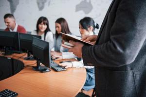 tenir des cahiers. groupe de personnes lors d'une conférence d'affaires dans une salle de classe moderne pendant la journée photo