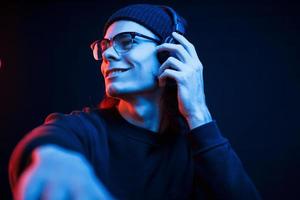DJ sur son travail. studio tourné en studio sombre avec néon. portrait d'homme sérieux photo