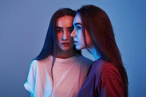 belles personnes. studio tourné à l'intérieur avec une lumière au néon. photo de deux beaux jumeaux