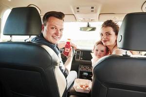 regarder en arrière. de belles personnes sont dans la voiture moderne le week-end photo