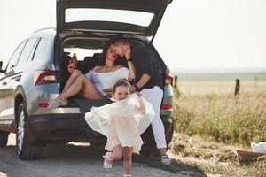 ambiance ludique. de belles personnes sont dans la voiture moderne le week-end photo