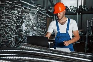 uniforme de couleur bleue. l'homme en uniforme travaille sur la production. technologie industrielle moderne photo