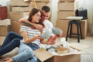 déballage des cartons. joyeux jeune couple dans leur nouvel appartement. conception du déménagement photo