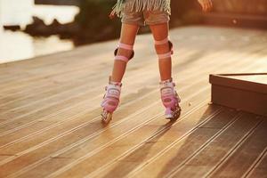 vue particulaire. enfant à cheval sur ses patins à roulettes. lumière du soleil incroyable photo