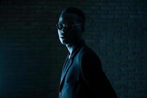 pièce sombre. jeune homme afro-américain dans le studio photo