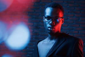 la lumière clignote. néon futuriste. jeune homme afro-américain dans le studio photo