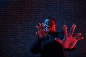 éclairage néon futuriste. jeune homme afro-américain dans le studio photo