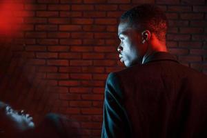 beau reflet. éclairage néon futuriste. jeune homme afro-américain dans le studio photo