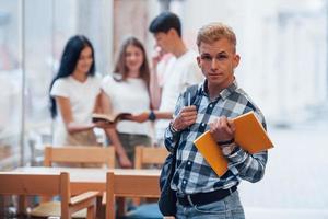 quatre jeunes étudiants en vêtements décontractés se réunissent le jour de la pluie photo