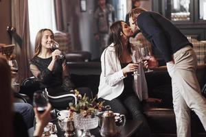 le temps de s'embrasser. amis de la famille s'amusant dans un beau restaurant moderne de luxe photo