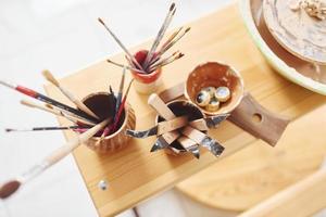 vue de dessus des pinceaux et autres outils de poterie qui se trouvent sur la table en bois photo