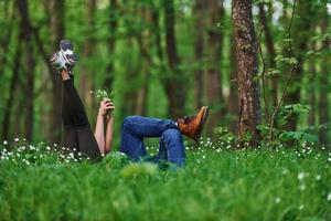 couple allongé sur l'herbe dans la forêt ensemble pendant la journée photo