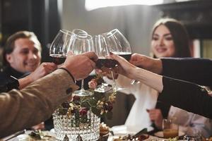 pour notre succès. amis de la famille s'amusant dans un beau restaurant moderne de luxe photo