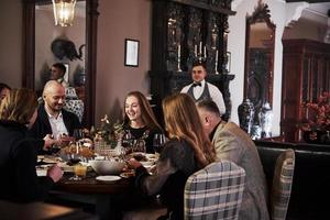 c'est un service professionnel. amis de la famille s'amusant dans un beau restaurant moderne de luxe photo