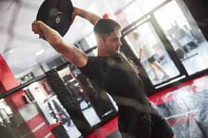 l'homme s'entraîne dans la salle de sport. avoir de l'exercice avec des crêpes pour la tige photo