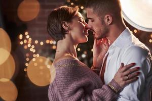 pendant une seconde avant un baiser. beau couple célébrant le nouvel an dans la salle décorée du nouvel an photo