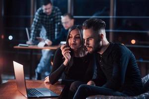 suit le processus. une équipe de jeunes hommes d'affaires travaille sur leur projet la nuit au bureau photo