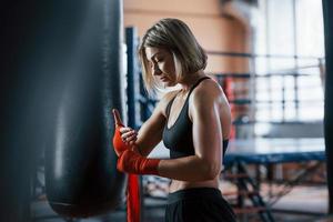 humeur calme. se préparer pour l'entraînement de boxe dans le gymnase. femme blonde adulte photo