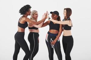 ensemble c'est plus facile. groupe de femmes multiethniques debout dans le studio sur fond blanc photo