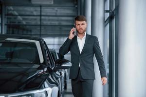 avoir une conversation. homme d'affaires barbu élégant et moderne dans le salon automobile photo