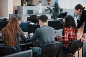 vue arrière. groupe de jeunes en vêtements décontractés travaillant dans le bureau moderne photo