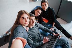 l'heure des selfies. groupe de jeunes en vêtements décontractés travaillant dans le bureau moderne photo