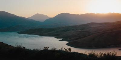 coucher de soleil sur les montagnes et un lac photo