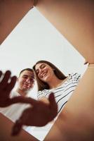 deux personnes regardent dans la boîte. conception du déménagement photo