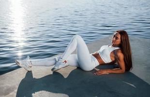 belle réflexion de la lumière du soleil sur la surface de l'eau. femme de remise en forme se reposer près du lac pendant la journée. beau soleil photo