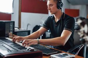 ingénieur du son dans les écouteurs travaillant et mélangeant de la musique à l'intérieur du studio photo