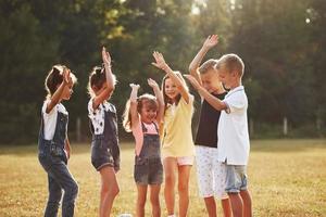 prêt pour le match. les jeunes enfants sportifs se rassemblent sur le terrain aux beaux jours photo