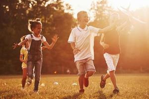 un groupe d'enfants a un week-end actif sur le terrain. illuminé par un beau soleil photo