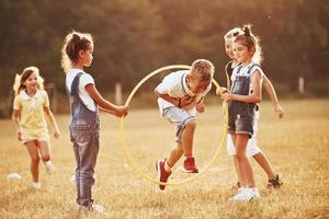 sauter à travers l'outil de fitness du cercle. les enfants s'amusent sur le terrain photo