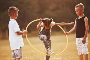 sauter à travers l'outil de fitness du cercle. les enfants s'amusent sur le terrain photo