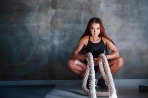 jeune femme de remise en forme avec un type de corps mince est assise avec des nœuds dans les mains photo