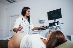 une femme médecin fait une échographie pour une femme enceinte à l'hôpital photo