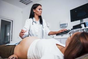 une femme médecin fait une échographie pour une femme enceinte à l'hôpital photo