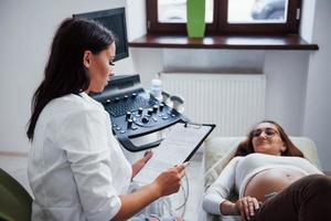 femme médecin parle des résultats de l'échographie pour une femme enceinte à l'hôpital photo