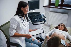 femme médecin parle des résultats de l'échographie pour une femme enceinte à l'hôpital photo