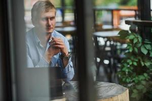 vue de face du gars qui est dans un café moderne avec son ordinateur portable pendant la journée photo