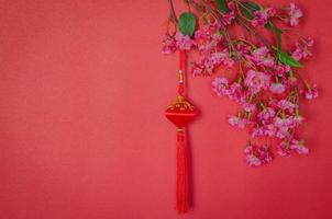 pendentif suspendu pour l'ornement du nouvel an chinois avec des fleurs de fleurs chinoises sur fond rouge. photo