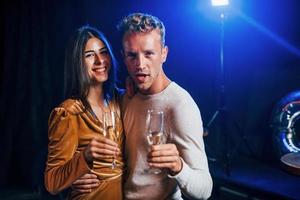 joli couple se tient ensemble à la fête avec de l'alcool dans les mains photo