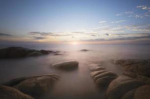 pierres dans la mer au coucher du soleil photo