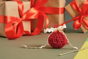 crochet, boule tricotée à la main pour noël et coffrets cadeaux avec rubans rouges sur fond vert photo